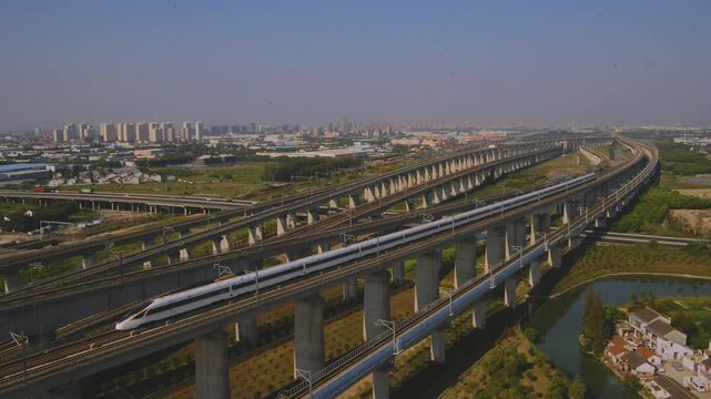 High-speed railway train traveling on the Beijing&ndash;Shanghai High-Speed Railway (Jinghu HSR) in China. Modern bullet train running on elevated tracks through the countryside, showcasing advanced transpo