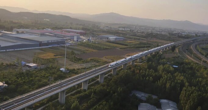 High-speed railway train traveling on the Beijing&ndash;Shanghai High-Speed Railway (Jinghu HSR) in China. Modern bullet train running on elevated tracks through the countryside, showcasing advanced transpo