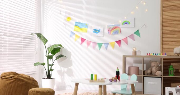 Stylish child's room with furniture, toys, beautiful drawings and bright flags, camera moving in. Interior design