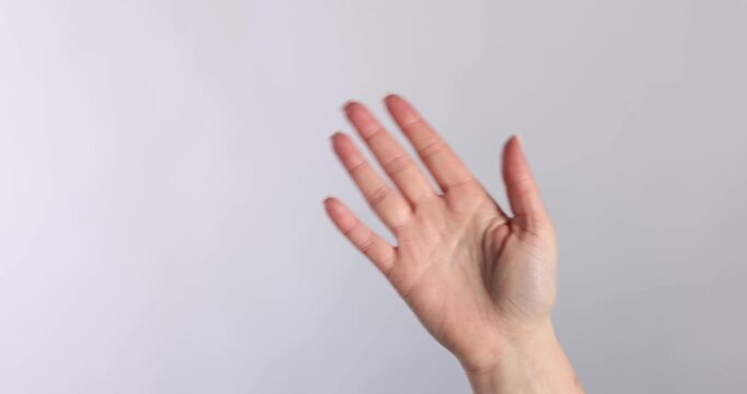 Welcome gesture. Woman waving on light grey background, closeup