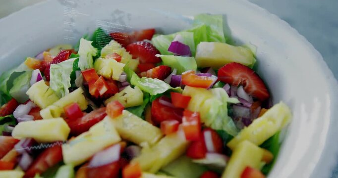 Camera pulling back, shifting focus over bowl, showing strawberries and pineapple for food ad