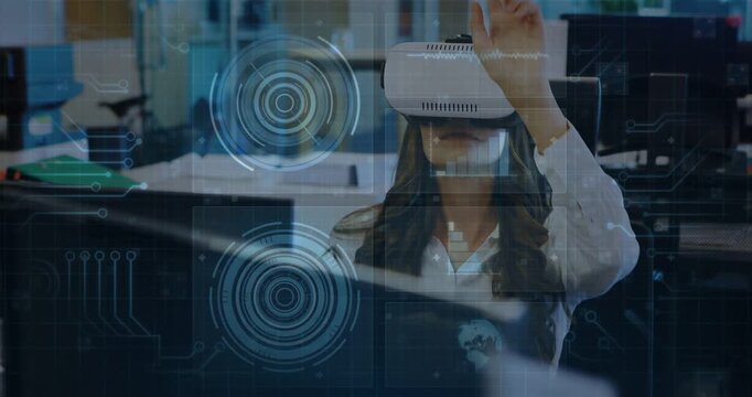 Vertical video: Woman VR user gesturing with holo UI appearing by monitor, controlling tech data