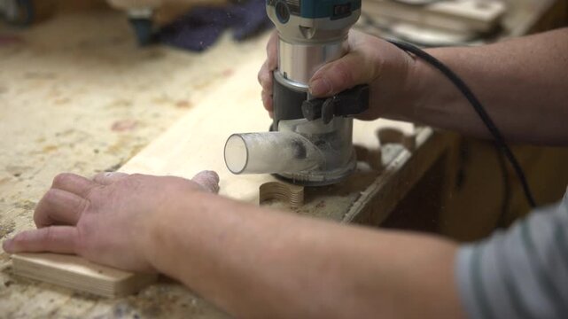 Edge Shaping With Handheld Tool. Steady Guiding Hand Performing Detailed Woodworking Profile Shaping. Media