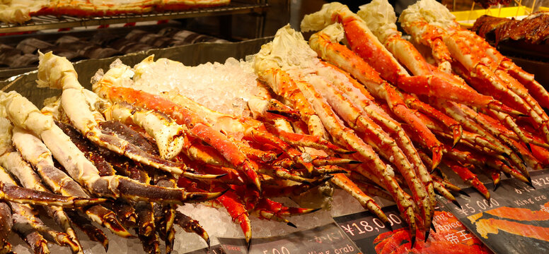 Frozen king crab legs on ice with price tags.
