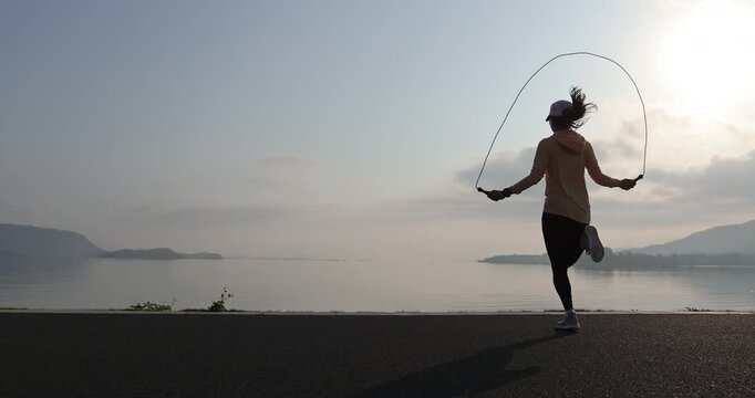 Fitness woman rope skipping  at seaside