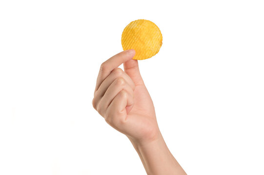  Hand holding  single corrugated yellow potato chip, isolated on  white background. Perfect for snack advertising, food branding, and delicious junk food .