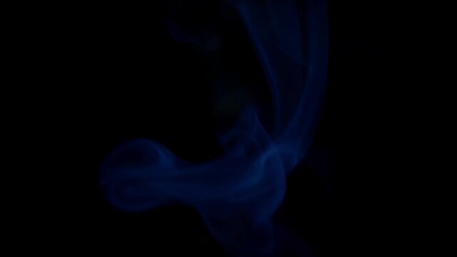 Abstract footage of flowing blue smoke drifting gracefully against a dark black background, creating a dramatic and cinematic atmospheric effect. The soft swirling vapor patterns