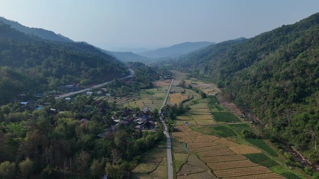 Aerial View of Serene Valley Lush Green Hills, Winding Road, and Patchwork Fields in Natures Landscape