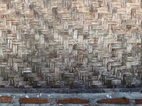Traditional woven bamboo walls with vertical posts, a natural texture of rural Indonesia.