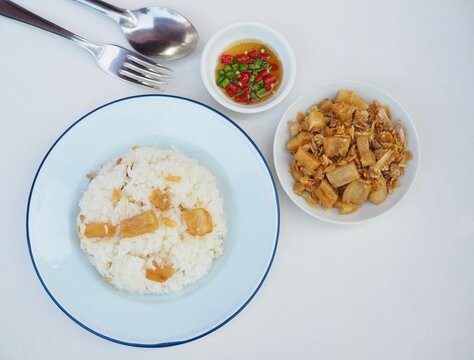 Pork cracklings with fried garlic, served with rice and fish sauce dip, are placed on a white background. They are golden yellow, look appetizing, and are very crispy and delicious.