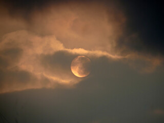 Fototapeta premium Glowing Sun Behind Clouds in a Dramatic Dawn Sky in Hanoi, Vietnam