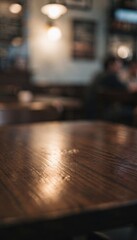 Dark wood table top in a blurred cafe restaurant setting, empty surface for pub or bar menu advertising and social media background with copy space and bokeh