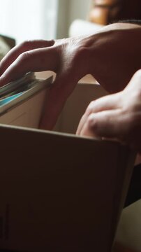 A close-up vertical shot of hands slowly leafing through paper folders in a metal filing drawer. Ideal for themes of bureaucracy, investigation, cold case research, and corporate history.