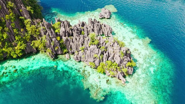 Top down view of limestone reef island in turquoise lagoon Coron Philippines