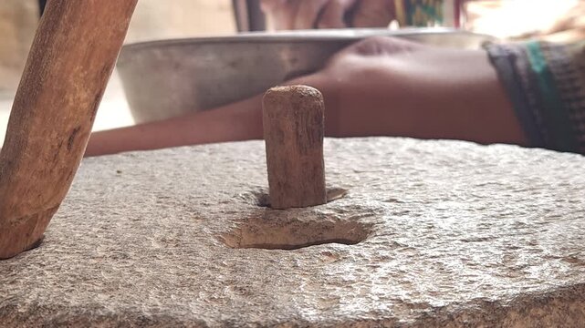 Close-Up of Woman Hand Operating Traditional Stone Grinder Chakki in India, Manual Grain Grinding Process, Rural Kitchen Tool, Authentic Village Lifestyle, Organic Food Preparation 4K Footage