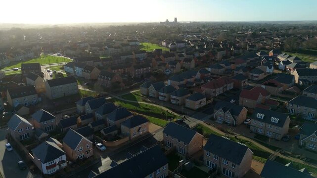 Drone view over the suburbs of Ely showing a bird&rsquo;s eye perspective of domestic architecture and family homes during the peak of golden hour