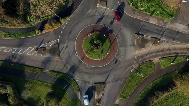 Hyperlapse aerial view of traffic flowing smoothly through a busy top down roundabout intersection in Ely Cambridgeshire on a bright day