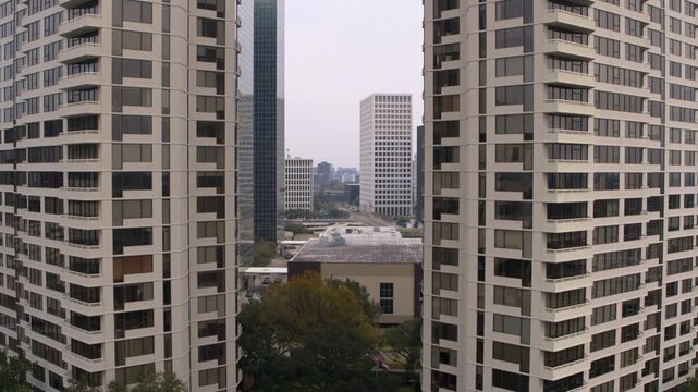 Pullback drone shot rising above luxury condos to reveal the full Houston skyline. Cinematic aerial footage perfect fo