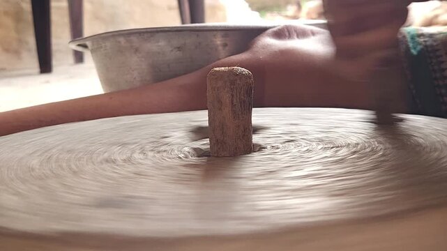 Close-Up of Woman Hand Operating Traditional Stone Grinder Chakki in India, Manual Grain Grinding Process, Rural Kitchen Tool, Authentic Village Lifestyle, Organic Food Preparation 4K Footage