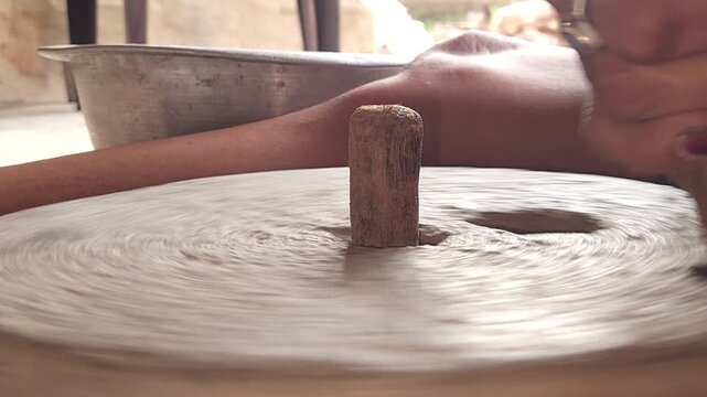 Close-Up of Woman Hand Operating Traditional Stone Grinder Chakki in India, Manual Grain Grinding Process, Rural Kitchen Tool, Authentic Village Lifestyle, Organic Food Preparation 4K Footage
