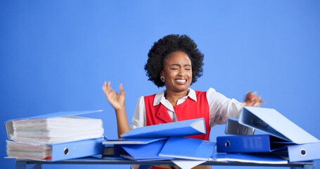 Business woman, chaos and documents in studio for stress, space and annoyed with file on blue...