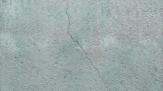 Cracked blue wall texture background, damaged plaster surface with fracture line, grunge abstract backdrop.