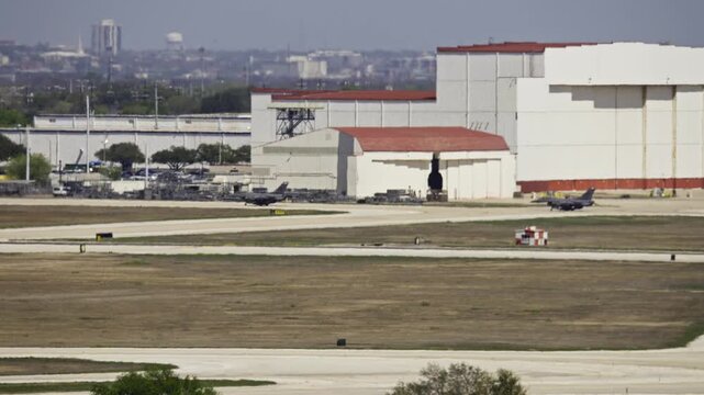 Two F-16 Fighter Jets Taxiing in Sequence on Military Air Base Runway