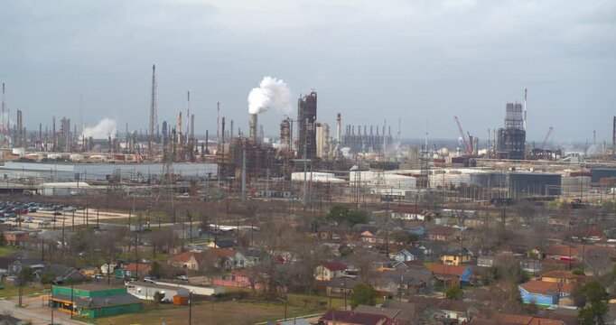 Establishing reveal shot of homes near heavy industry and chemical plants in the Baytown, Texas area