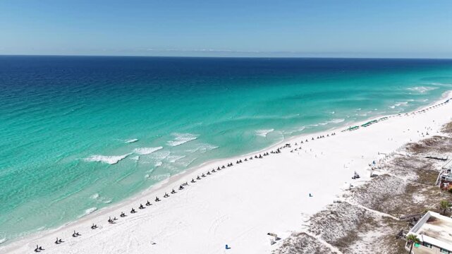 Long aerial coastline of emerald Gulf water and white sandy beach stretching into distant horizon, 30A, Florida, USA