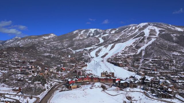 Steamboat Ski Resort Spring Winter morning sunny blue sky Steamboat Springs Colorado aerial drone fresh snow groomed ski trails Olympic training moguls chairlift Sunshine Peak upwards pan right