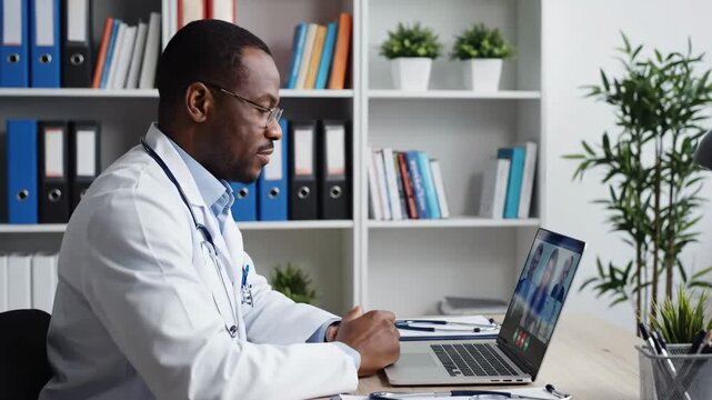Professional Telemedicine Consultation with an African American doctor using a laptop for a video conference in a modern clinic, ideal for healthcare services and remote medical advice concepts.