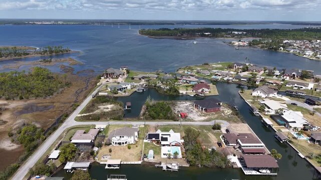 Aerial drone view over coastal lagoon neighborhood with swampy ground and developed waterfront houses, 30A, Florida, USA