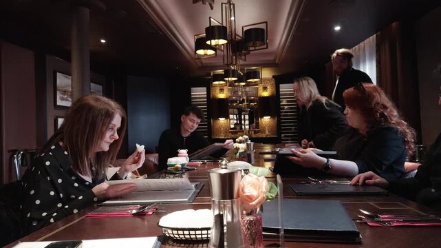 Family members gathered for dinner in an elegant restaurant private room, sharing conversation, connection and a warm celebratory mealtime atmosphere indoors