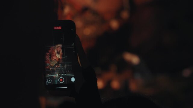 Ogoh Ogoh festival in Bali captured on smartphone by crowd at night, people recording traditional parade and ritual