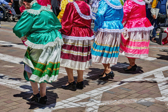 Participants in traditional Ecuadorian folklore parade wearing colorful dresses with intricate designs, Bailarinas de Folklore dancing showcasing vibrant skirts and lively on a city street