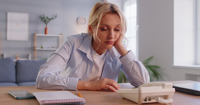 Worried woman looking at desk phone, waiting for call, frustrated by received answer or notification, bad news, feels upset, waiting message from boss, negative response, bored and impatient 