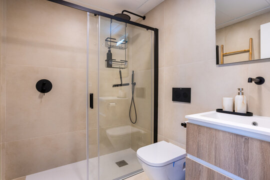 Modern bathroom with walk in glass shower, wooden vanity and minimalist contemporary apartment interior design