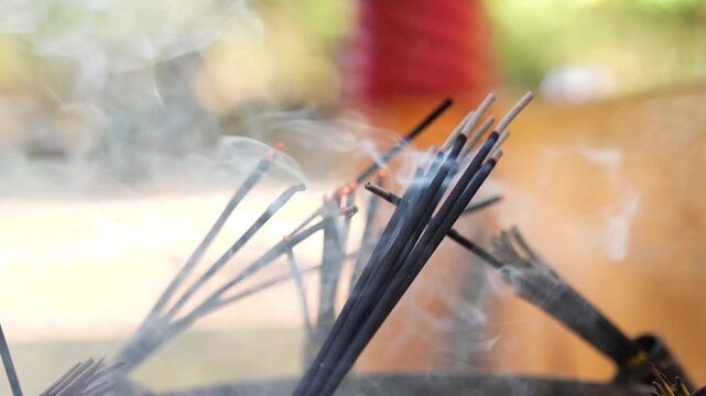 Incense sticks burning inside a temple, with soft smoke rising in the air. The scene represents spiritual rituals, prayer, and a calm devotional atmosphere.