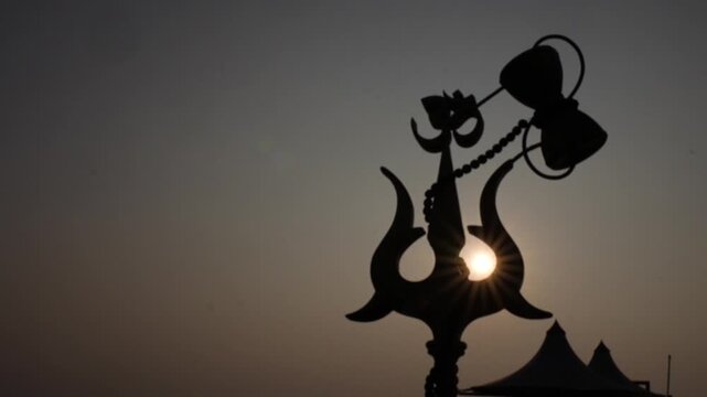 Silhouette of Lord Shiva Trishul and Damru at Sunset &ndash; Hindu Spiritual Symbol in Dramatic Sky