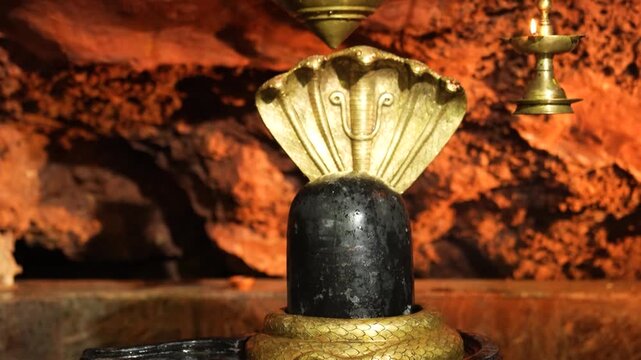 Closeup of Shivling with Golden Serpent (Sheshnag) Inside Hindu Temple &ndash; Sacred Shiva Symbol.