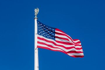 Fototapeta premium Flag American waving in bright sky. American patriotic banner on freedom flag. USA democracy liberty symbol in flag. American culture independence on flag.
