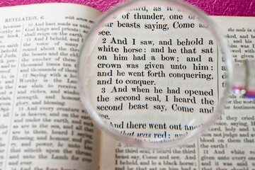 Fototapeta premium Words from the pages of the holy Christian bible verse Revelation 6:2 describing a white horse with bow and crown; the King James Version of the scripture.