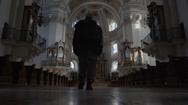 Person standing inside ornate baroque church interior looking up