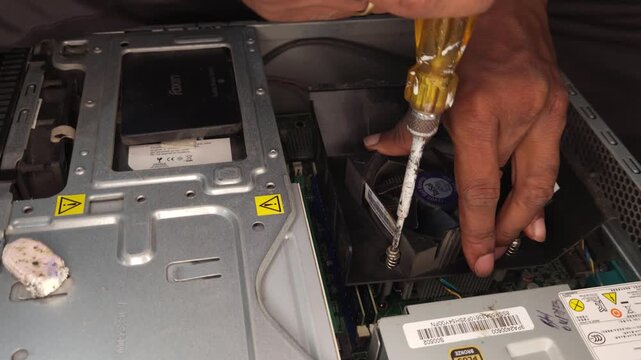 Technician repairing desktop computer with screwdriver, close up motherboard and internal components, IT maintenance scene showing fixing, upgrading and troubleshooting PC in workspace environment