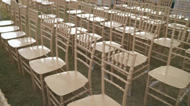 Empty Rows of Elegant Cream Chiavari Chairs for Outdoor Wedding Ceremony or Luxury Garden Party Event