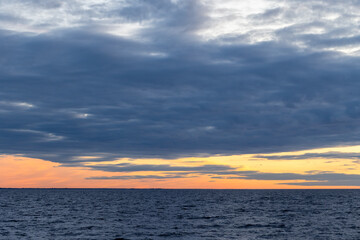 Obraz premium Coastal landscape photo featuring dark cloudy sky over the horizon at sunset. Baltic Sea landscape