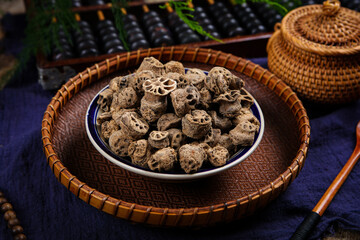 Fototapeta premium Dried medicinal roots in bowl on woven tray