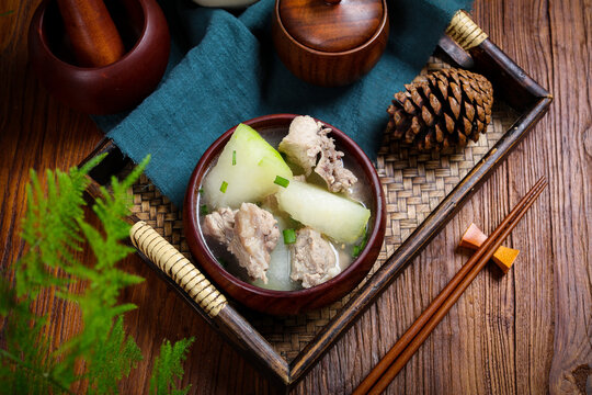 Winter melon soup with pork in rustic Asian setting