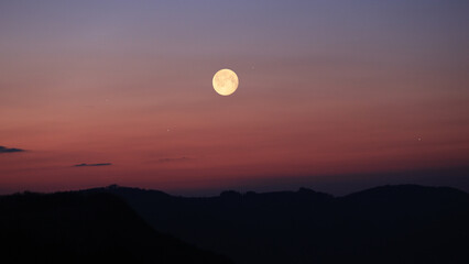 Fototapeta premium Full Moon, stars and planets above landscape silhouettes.