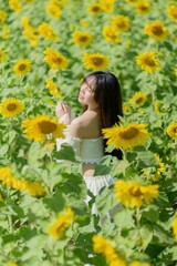 Naklejka premium Beautiful Woman Posing in Vibrant Sunflower Field During Spring
